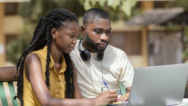 Deux étudiants travaillent ensemble sur un ordinateur portable