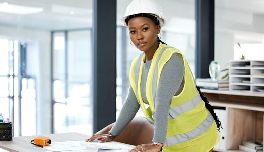 Une ingénieure annote des plans d'aménagement sur son bureau